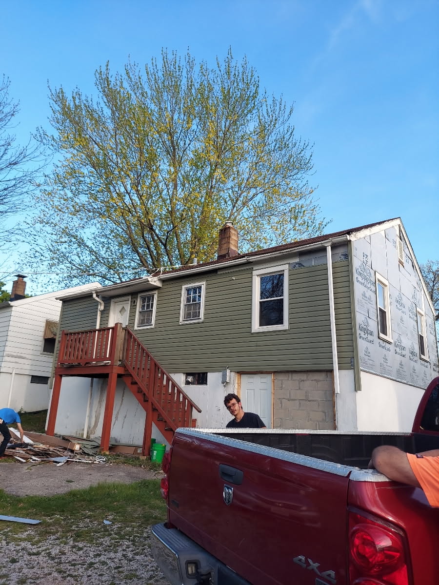 House under renovation with red truck and tree in spring